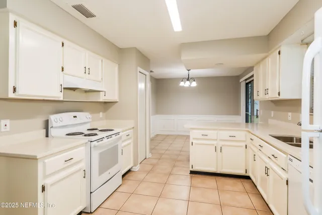 a kitchen with white cabinets appliances and sink