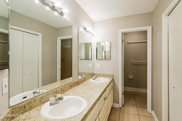 a bathroom with a double vanity sink and a mirror