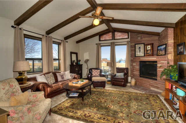 1363 21 Road Fruita, CO 81521 - Photo 2 of 9 a living room with furniture a fireplace and a table