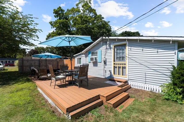 a view of a roof deck with table and chairs under an umbrella