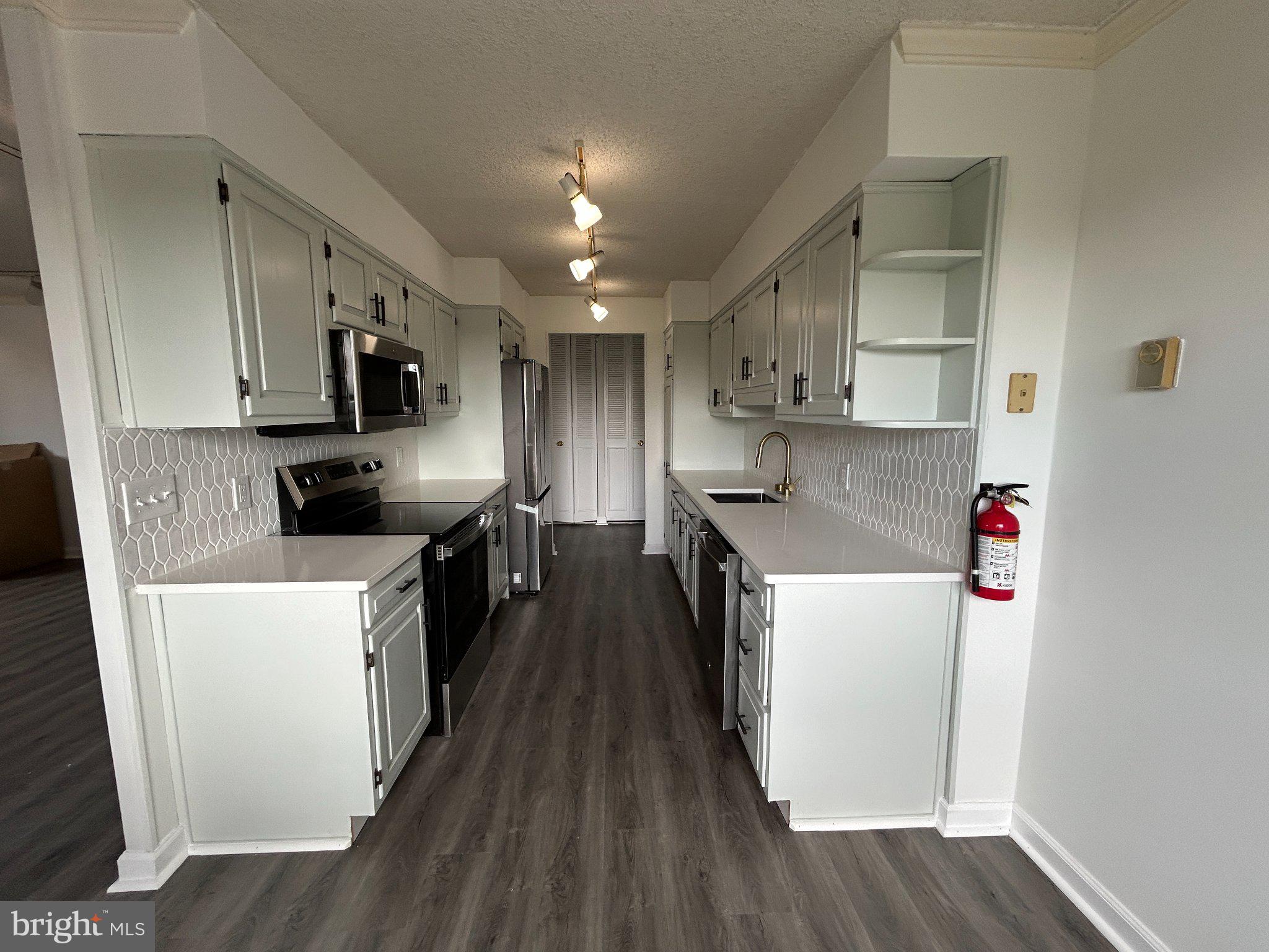 860 Lower Ferry Road, Unit 6M Ewing, NJ 08628 - Photo 5 of 16 a kitchen with kitchen island wooden floors and stainless steel appliances