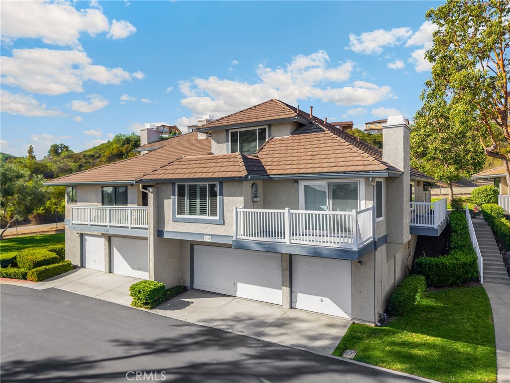 a front view of a house with a yard and potted plants