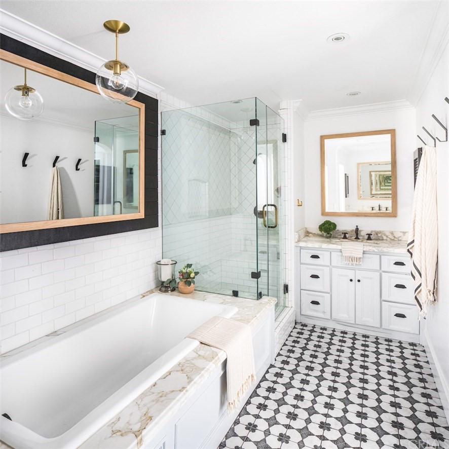 418 Broadway Costa Mesa, CA 92627 - Photo 12 of 27 a bathroom with a double vanity sink a mirror and a bathtub