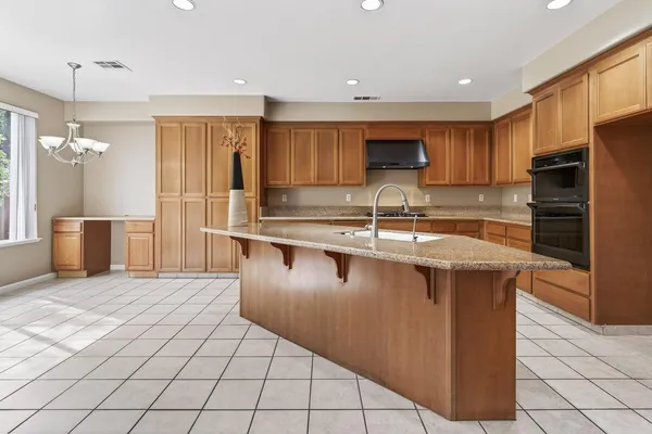 a kitchen with stainless steel appliances granite countertop a sink counter space cabinets and a refrigerator