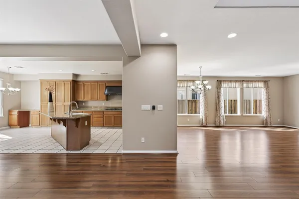 a view of a kitchen with refrigerator and wooden floor