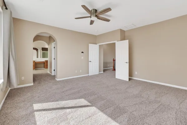 a view of a room with a ceiling fan and a rug