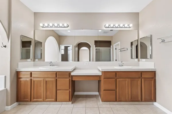a spacious bathroom with a granite countertop sink a mirror and a vanity