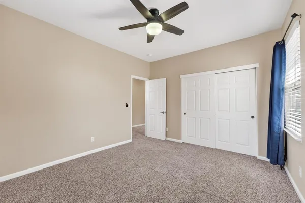 a view of a livingroom with a ceiling fan and window