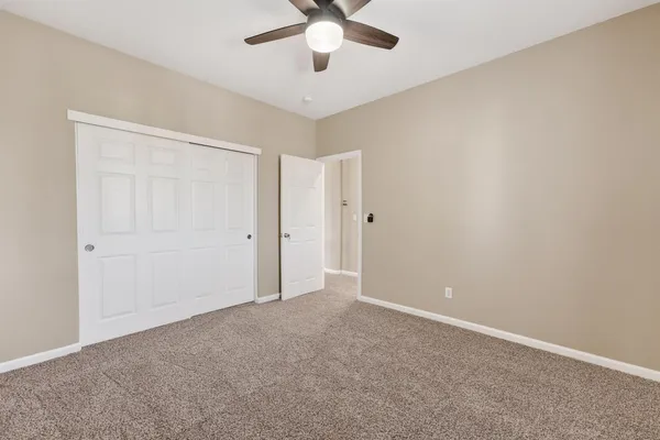 an empty room with chandelier fan