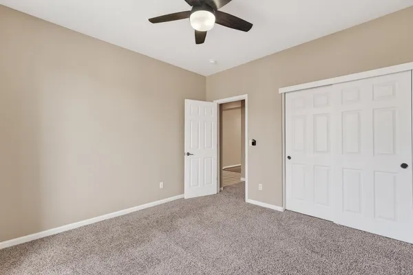 an empty room with chandelier fan