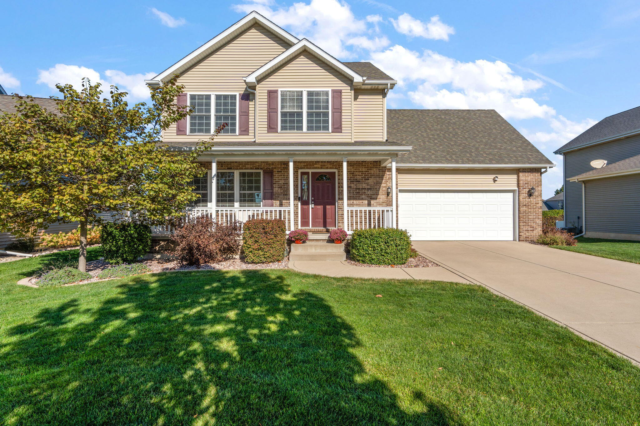 a front view of a house with a yard and trees