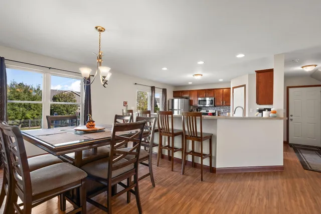 a view of a dining room and livingroom with furniture wooden floor a chandelier