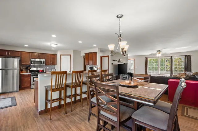a view of a dining room and livingroom with furniture wooden floor a chandelier