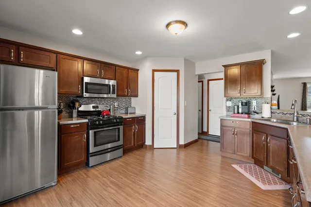 a kitchen with stainless steel appliances granite countertop a refrigerator stove and sink