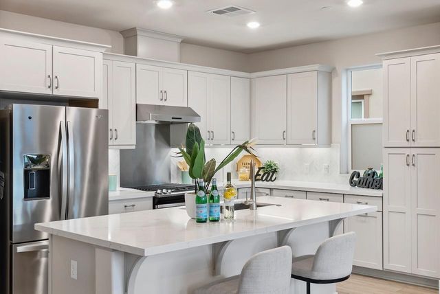 a kitchen with granite countertop a white cabinets and refrigerator