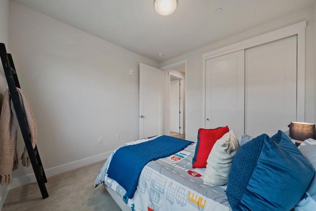 a bathroom with a granite countertop sink a mirror a vanity and a toilet
