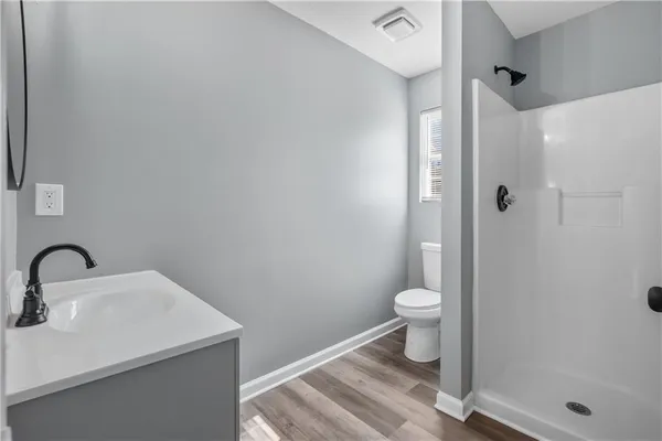 a bathroom with a sink a toilet and shower