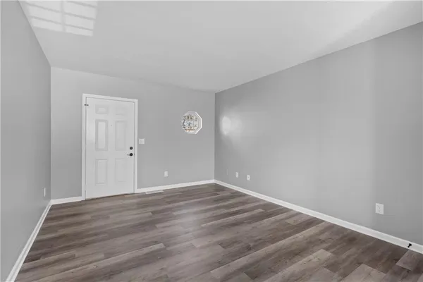 a view of an empty room with wooden floor