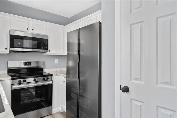 a kitchen with stainless steel appliances white cabinets and a stove top oven