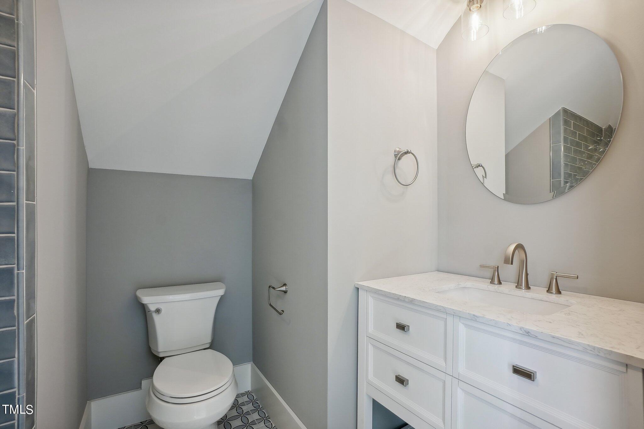 103 Pineland Circle Raleigh, NC 27606 - Photo 38 of 62 a bathroom with a toilet a sink a mirror and vanity