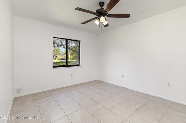 an empty room with a window and a fan