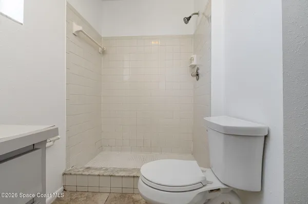 a white toilet sitting next to a shower