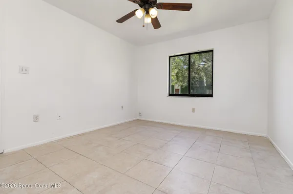 an empty room with chandelier fan