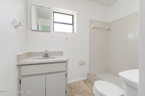 a bathroom with a toilet sink a mirror and vanity