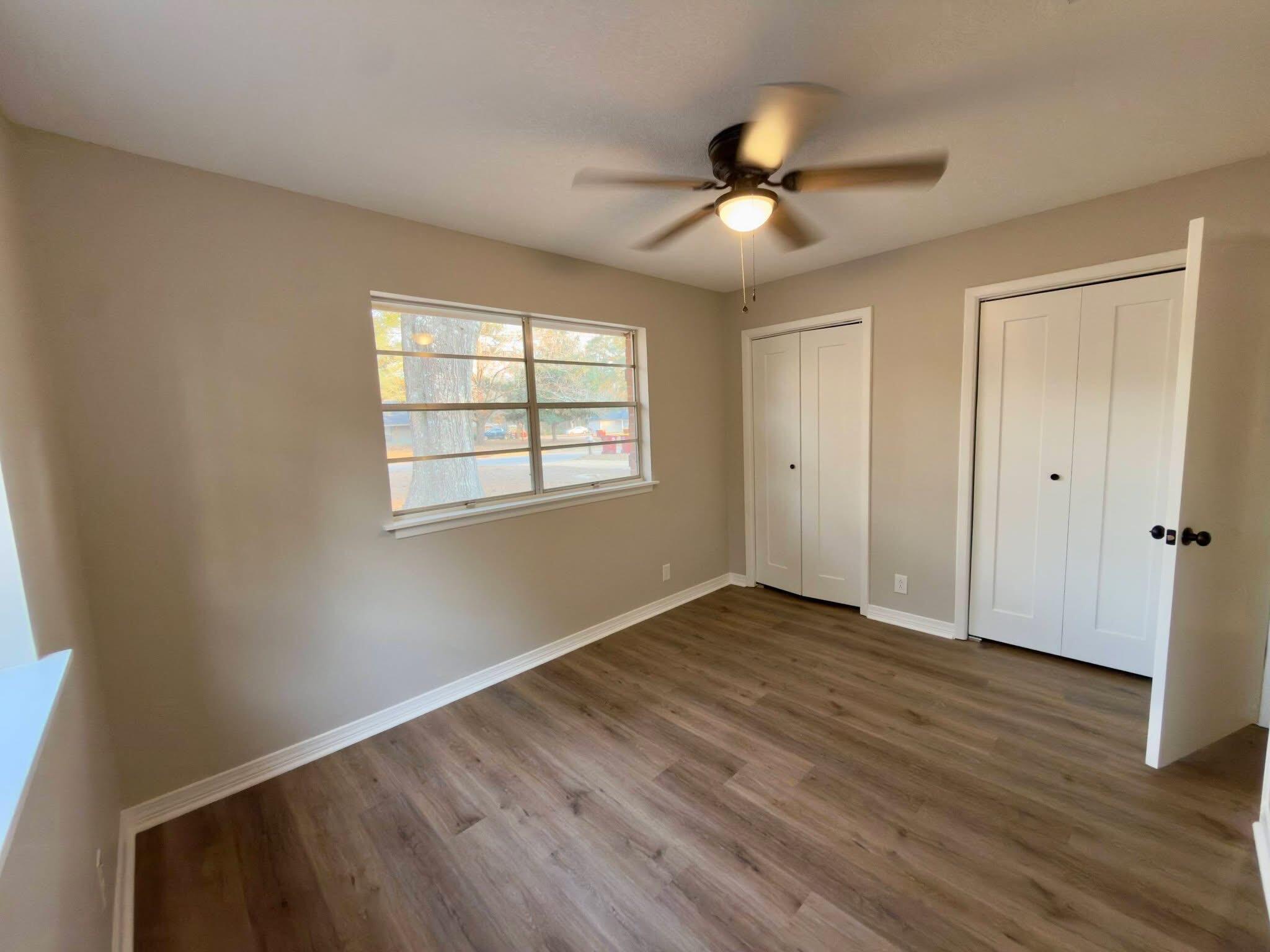 215 Jones Road Crestview, FL 32536 - Photo 2 of 9 a view of an empty room with wooden floor and a window
