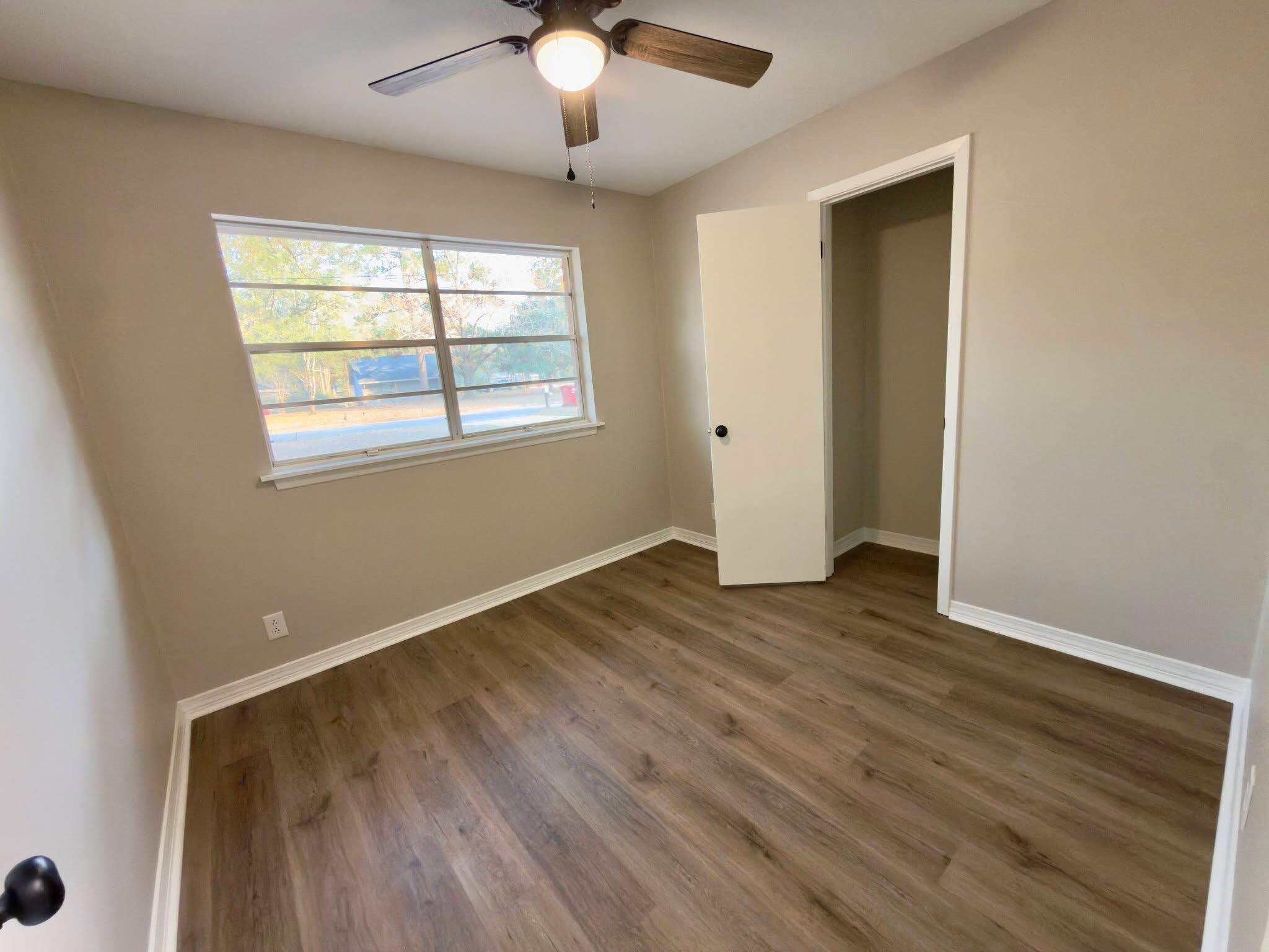 215 Jones Road Crestview, FL 32536 - Photo 6 of 9 a view of an empty room with wooden floor and a window