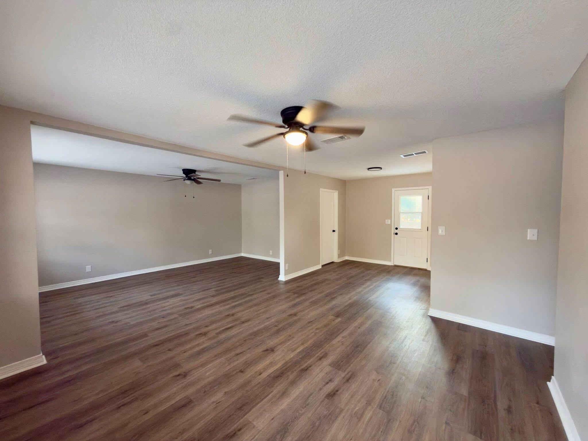 215 Jones Road Crestview, FL 32536 - Photo 8 of 9 a view of an empty room with wooden floor and a ceiling fan