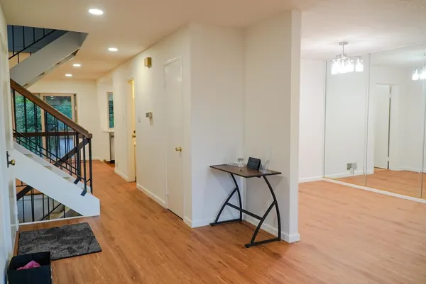 a view of a hallway with wooden floor and staircase