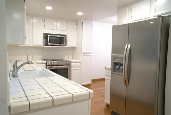 a kitchen with stainless steel appliances a refrigerator sink and microwave