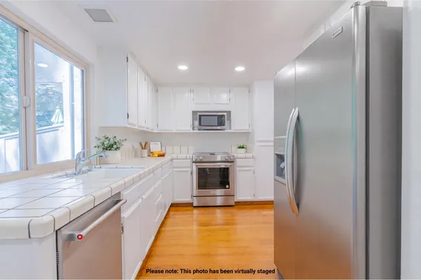 a large kitchen with granite countertop a stove and a refrigerator