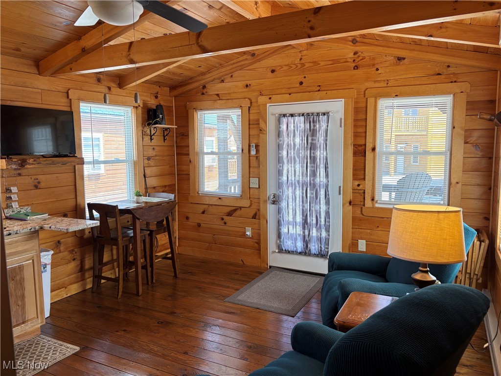 5919 Lake Road West, Unit 18 Ashtabula, OH 44004 - Photo 11 of 32 Living area with dark wood-style floors, healthy amount of natural light, wood ceiling, wooden walls, and a ceiling fan