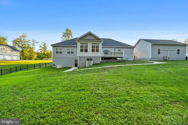 a view of a house with a big yard and potted plants in front of door