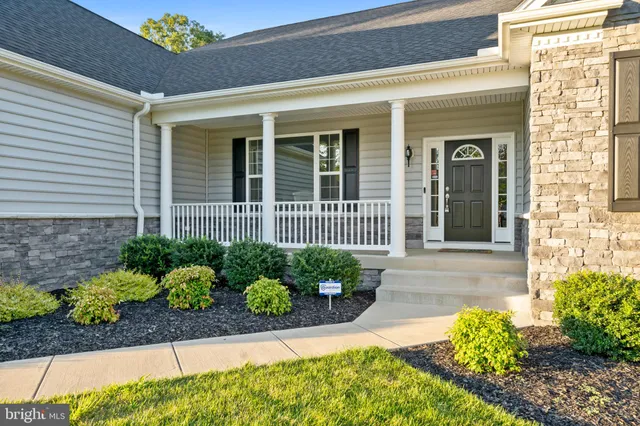 a view of a house with a big yard and large trees