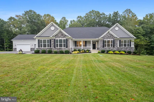 a view of a house with a big yard and large trees