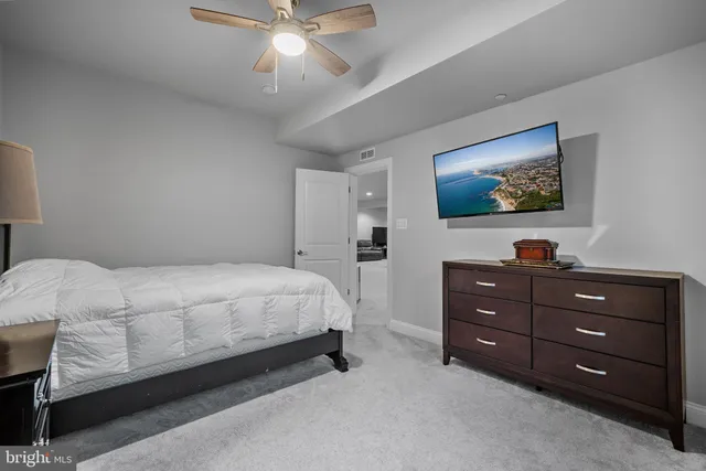 a bathroom with a double vanity sink a toilet a mirror and shower