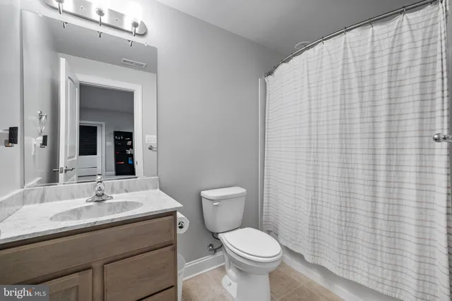 a bathroom with a granite countertop bathtub a sink and a large mirror
