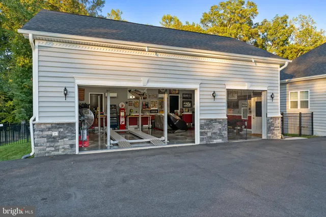 a front view of a house with yard and large tree