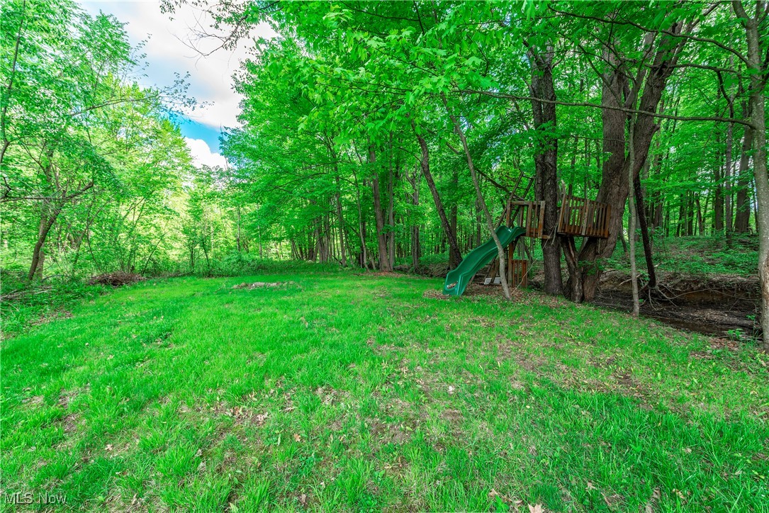 8080 Fair Road Strongsville, OH 44149 - Photo 44 of 50 View of green lawn featuring a playground and a wooded view