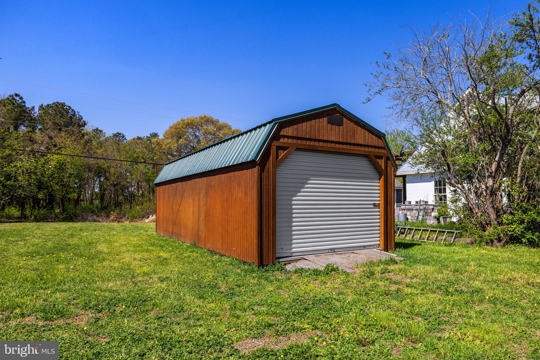 4809 Coles Point Road Hague, VA 22469 - Photo 42 of 49 Charming shed in a lush green setting.