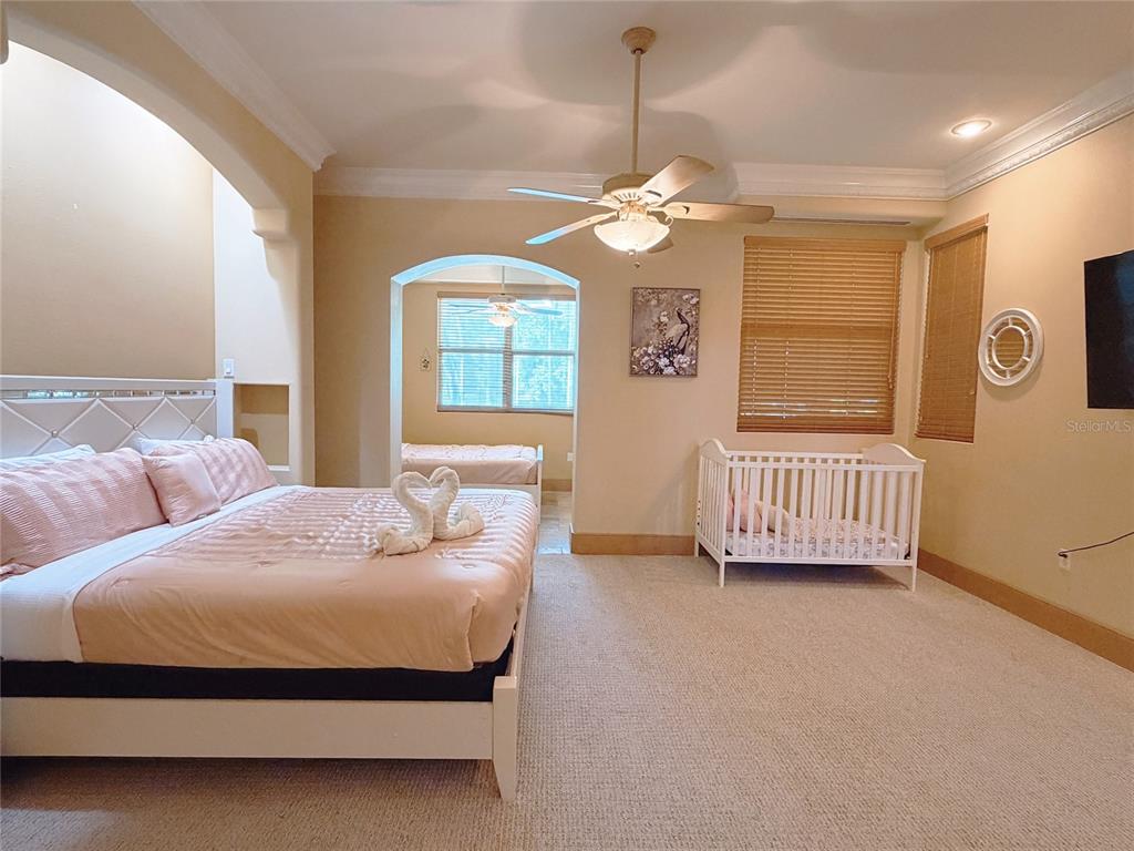 4421 Reaves Road Kissimmee, FL 34746 - Photo 19 of 100 a bedroom with a bed window and a chandelier