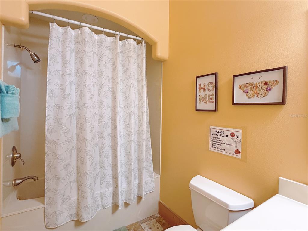 4421 Reaves Road Kissimmee, FL 34746 - Photo 57 of 100 a white toilet sitting next to a shower curtain