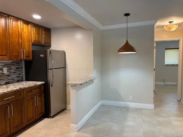 a kitchen with stainless steel appliances granite countertop a refrigerator a sink and a stove