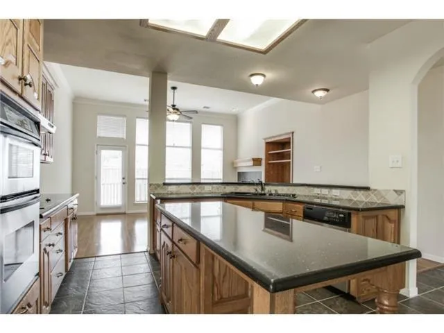 a kitchen with stainless steel appliances granite countertop a stove a sink and a microwave