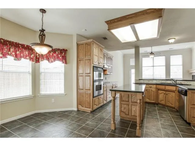 a kitchen with stainless steel appliances kitchen island granite countertop a refrigerator and microwave
