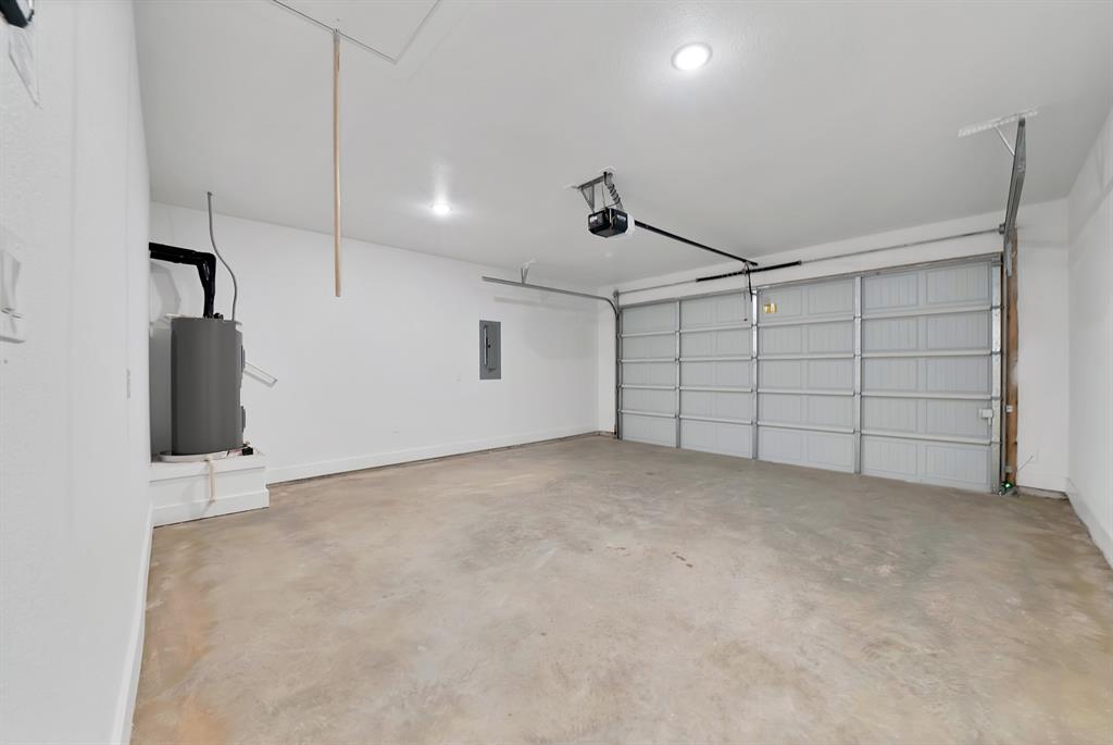 805 Tierney Road Fort Worth, TX 76112 - Photo 20 of 36 Concrete floor, white walls, overhead lighting, garage door, automatic garage door opener