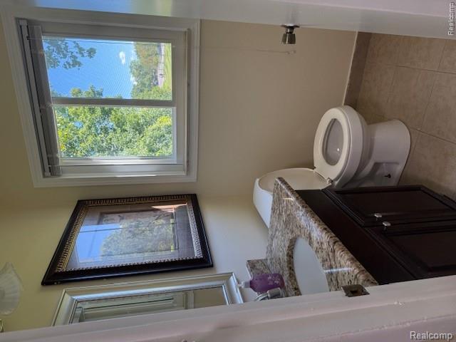 43038 Hanford Road Canton, MI 48187 - Photo 30 of 36 Bathroom featuring a vanity with a light-toned stone countertop, an integrated sink, and dark wood cabinetry with silver-tone hardware